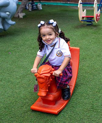 A young student on a rocking horse in the playground