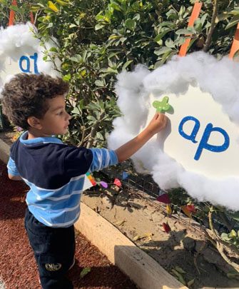 A young student at an alphabet display in the school garden